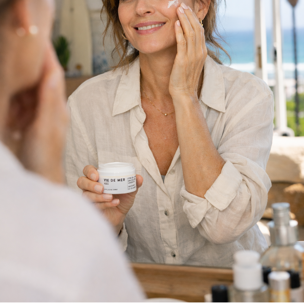 Woman putting on Vie de Mer Paris in Mirror