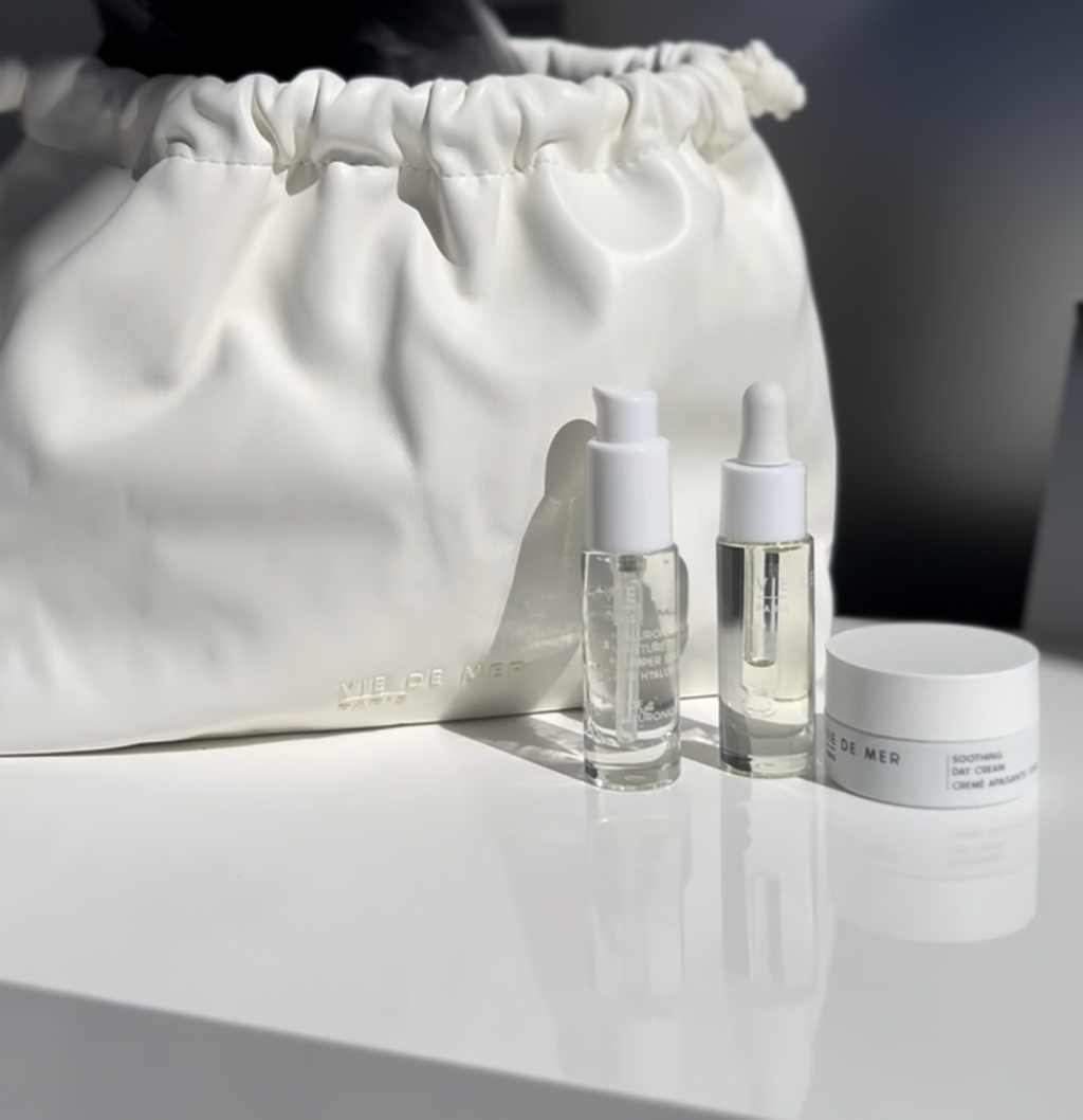 Cosmetic bag with skincare products on a white surface.